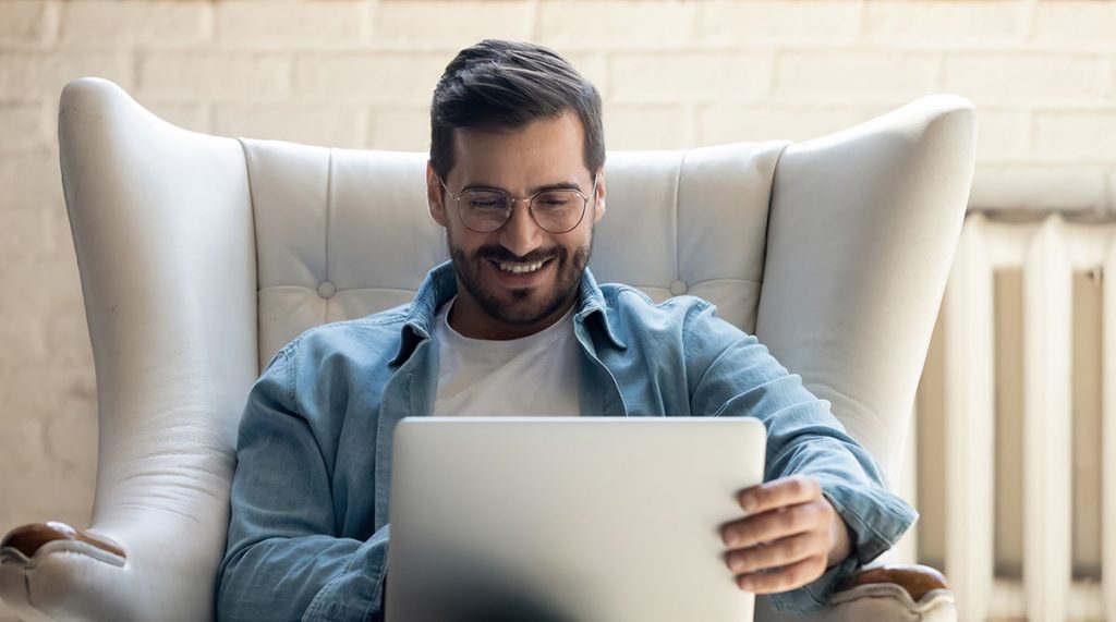 Mann entspannt mit Laptop und easybill im Sessel