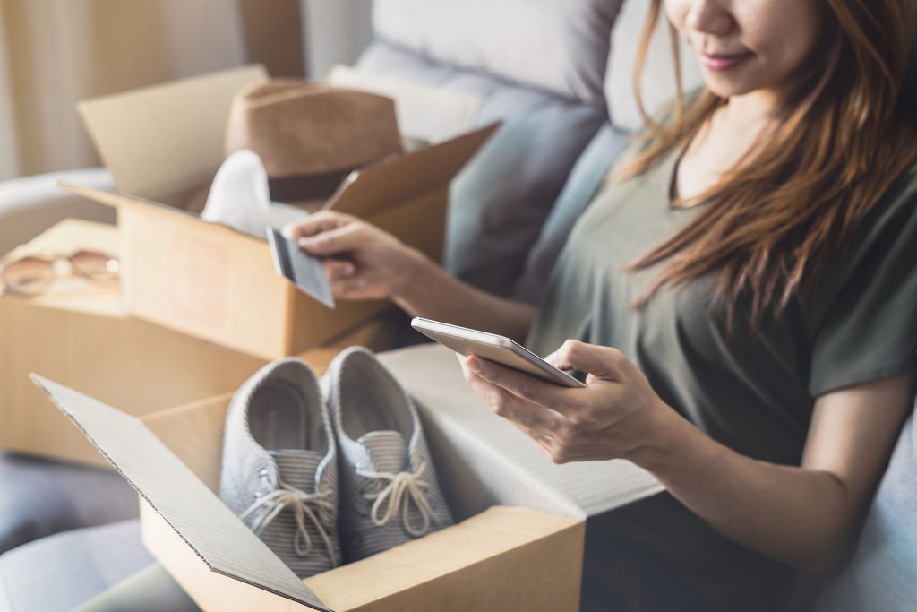 Frau hat Schuhe auf einem online Marktplatz gekauft, die sich im Karton befinden