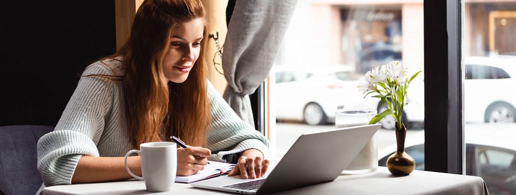 Frau arbeitet im Cafe mit easybill am Laptop remote