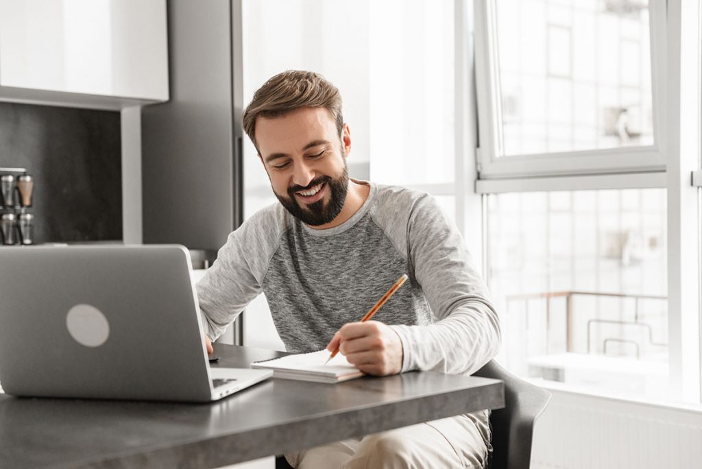 Mann erstellt wiederkehrende Rechnungen online mit easybill am Laptop