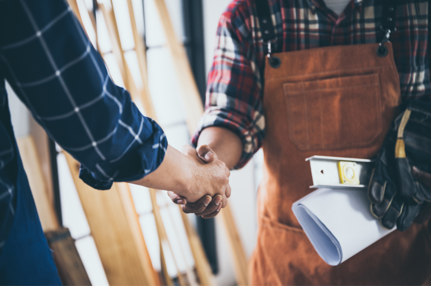 Handwerker bekommt einen Auftrag. Handschlag zwischen Handwerker und Kunde.