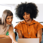 Zwei Frauen arbeiten zusammen an einem Laptop in einem Bekleidungsgeschäft, Amazon Verkauf, Amazon Selling Partner Appstore