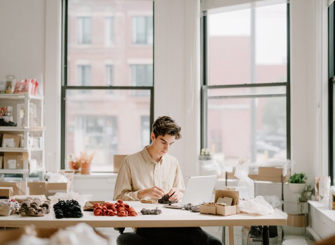 Illustration einer Frau, die an einem Laptop arbeitet, mit einer Kaffeetasse und Pflanzen im Hintergrund