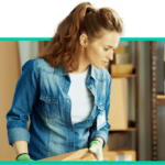 Eine Mitarbeiterin im Lager bearbeitet Pakete für den Versand, symbolisch für die Logistik im E-Commerce.