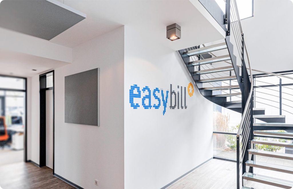 Modernes Bürogebäude von easybill mit Treppenhaus und Firmenlogo an der Wand