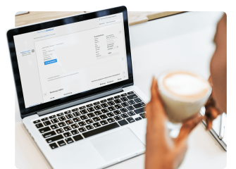 Person nutzt easybill Software zur Erstellung von Rechnungen auf einem Laptop, mit detaillierter Ansicht des Rechnungsentwurfs und einer Tasse Kaffee in der Hand.