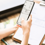 Person scannt eine Rechnung mit dem Smartphone zur digitalen Erfassung.