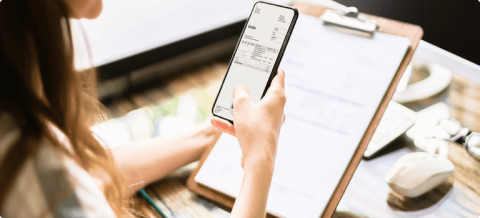 Person scannt eine Rechnung mit dem Smartphone zur digitalen Erfassung.