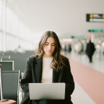 Ein Lagerarbeiter überprüft Waren auf Paletten und führt eine Bestandskontrolle durch. Im Vordergrund hält er ein Klemmbrett und notiert Details, während im Hintergrund gestapelte Kartons zu sehen sind.